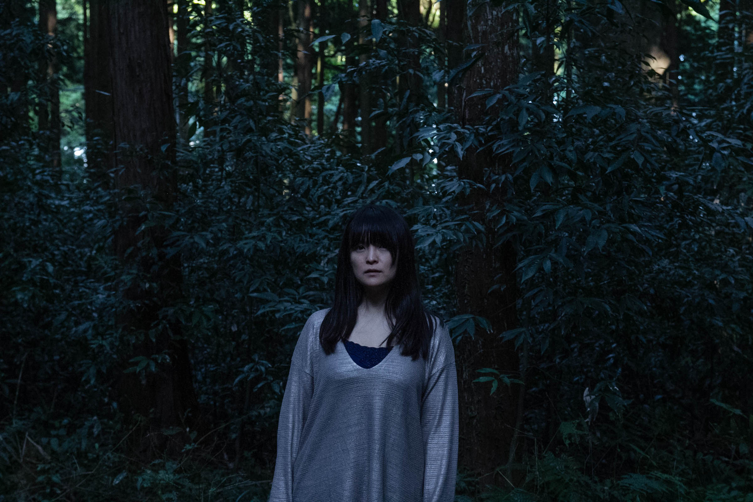 森の中に立つ神山亜希子さん